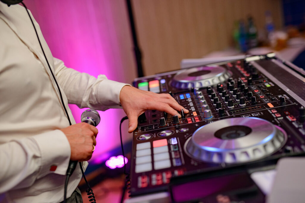 DJ plays music at wedding party. Colorful light rays